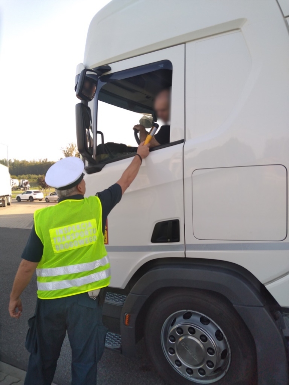 Inspektor ITD sprawdza trzeźwość kierowcy ciężarówki.